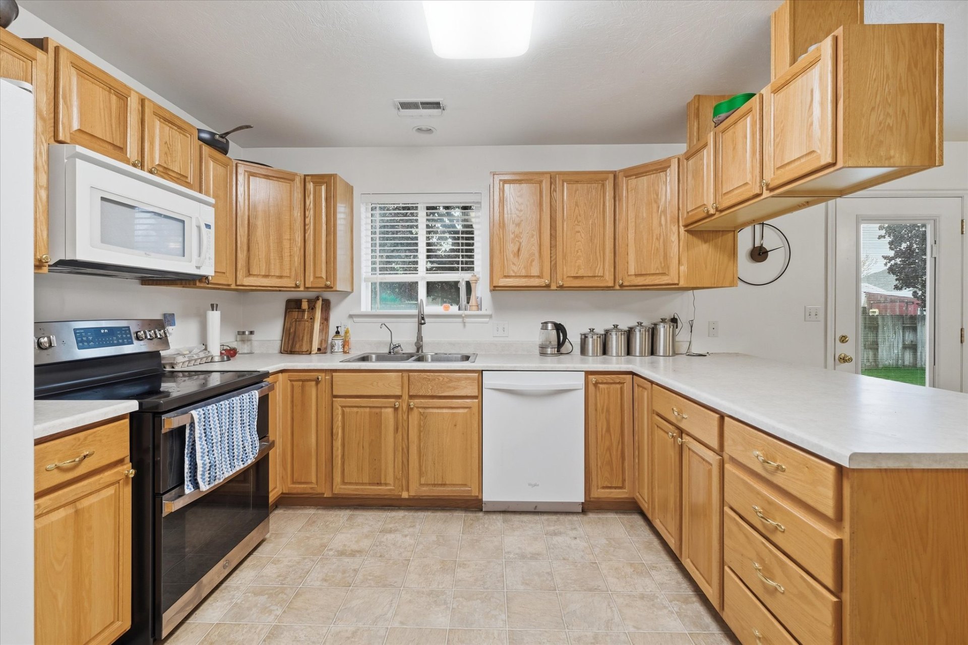 Bright kitchen with oak cabinetry, full appliance package and tile flooring