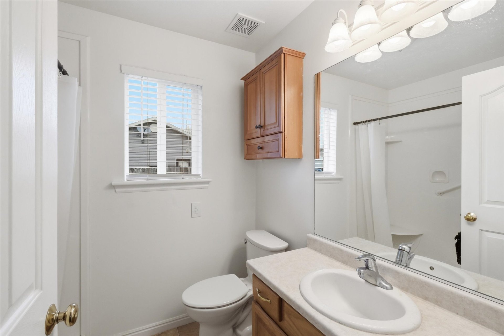 Full bathroom with vanity, tub-shower combo and storage cabinet